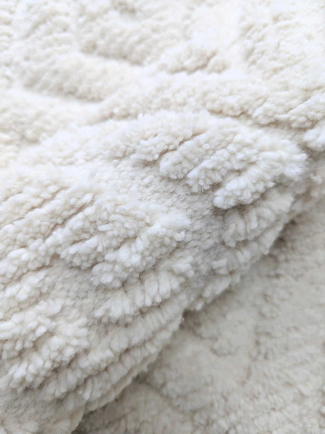 Close up of thick pile on cream natural wool berber rug