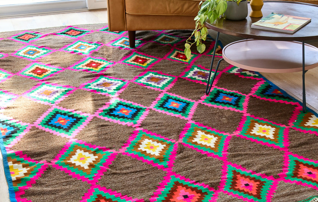 Multicoloured diamond berber rug with leather sofa and table on in a sunlit room